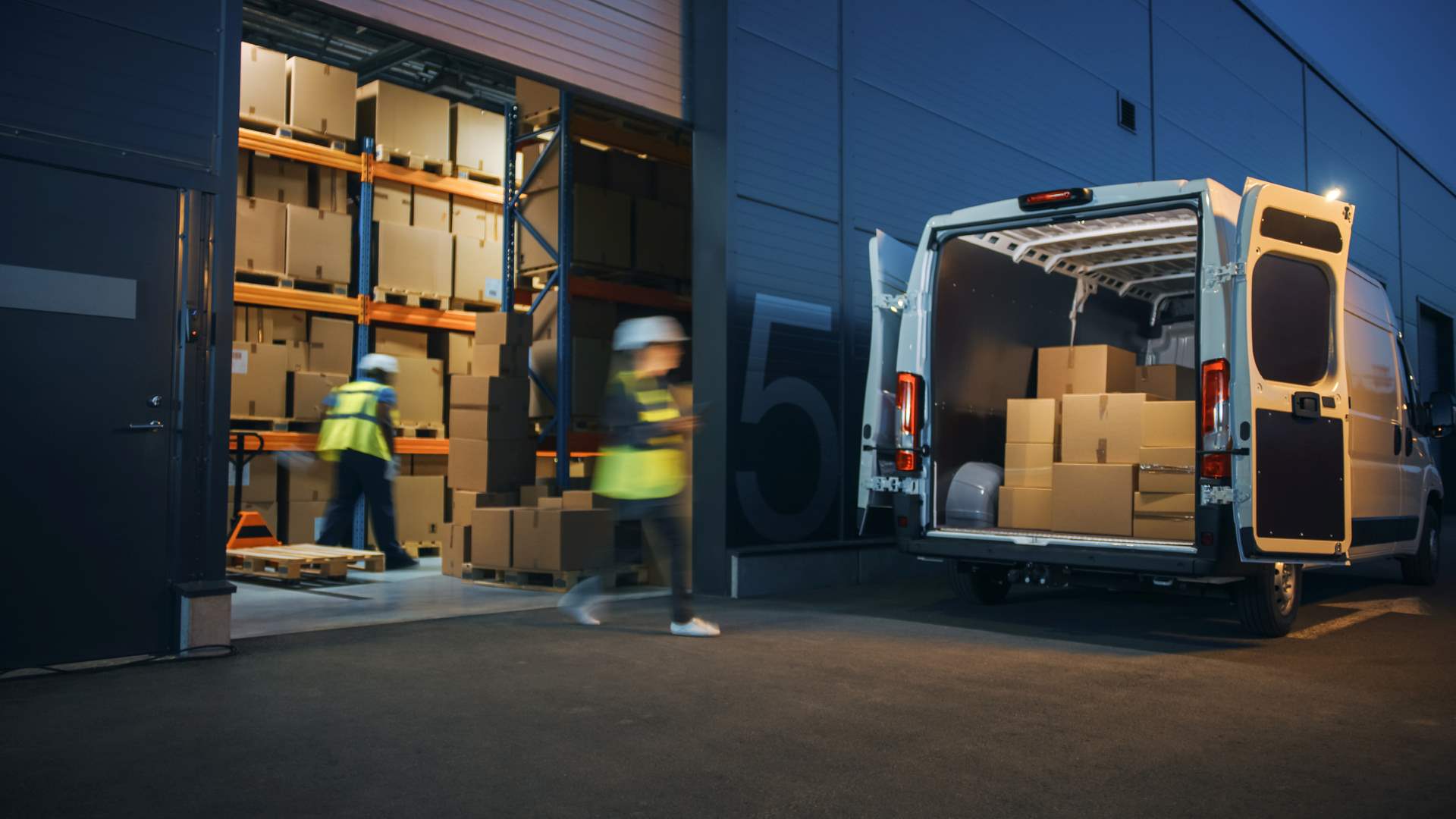 Loading courier van at warehouse with parcels ready for shipping