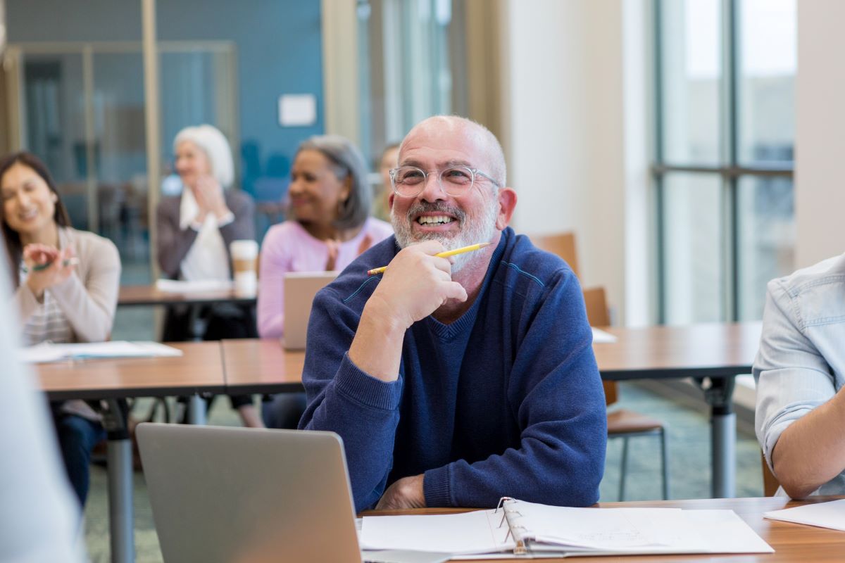 smiling workshop participant with notes and laptop